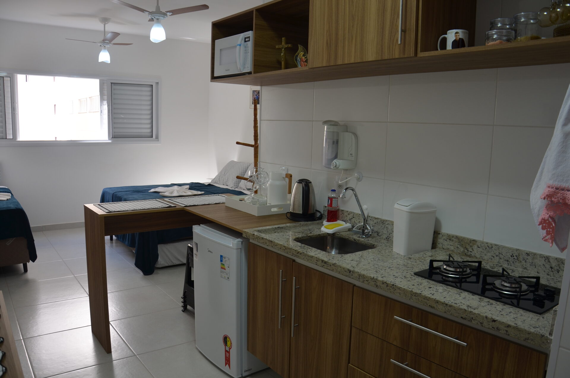 Cozinha equipada do Apartamento 313 com geladeira, fogão e pia — Kadosch Empreendimentos, Cachoeira Paulista/SP, perto da Canção Nova