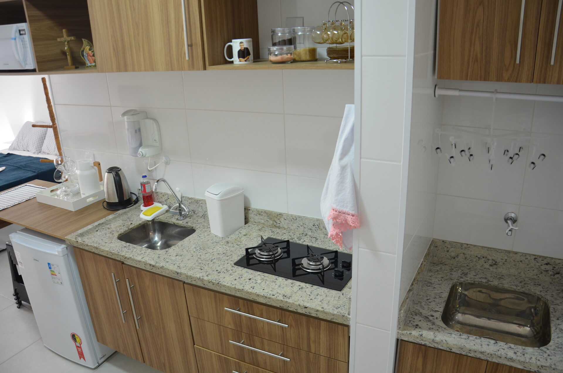Bancada da cozinha do Apartamento 313 com cooktop e utensílios — Kadosch Empreendimentos, Cachoeira Paulista/SP, perto da Canção Nova